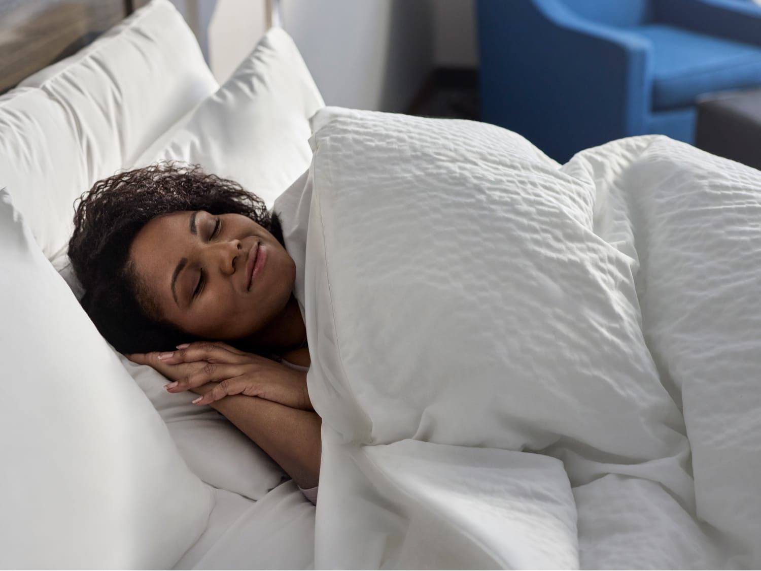 Một người phụ nữ ngủ ngon lành trong chiếc giường mềm mại tại khách sạn Garner.