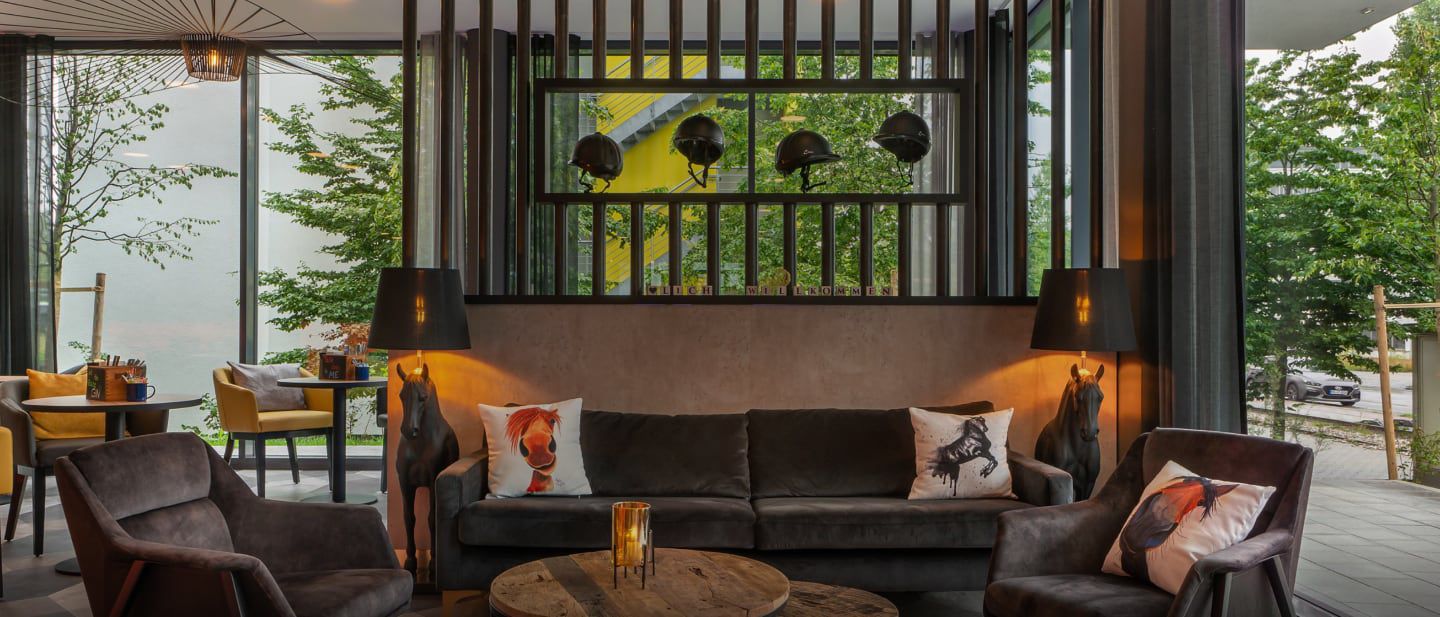 Stylish hotel lounge with dark sofas, art pillows, and decor.