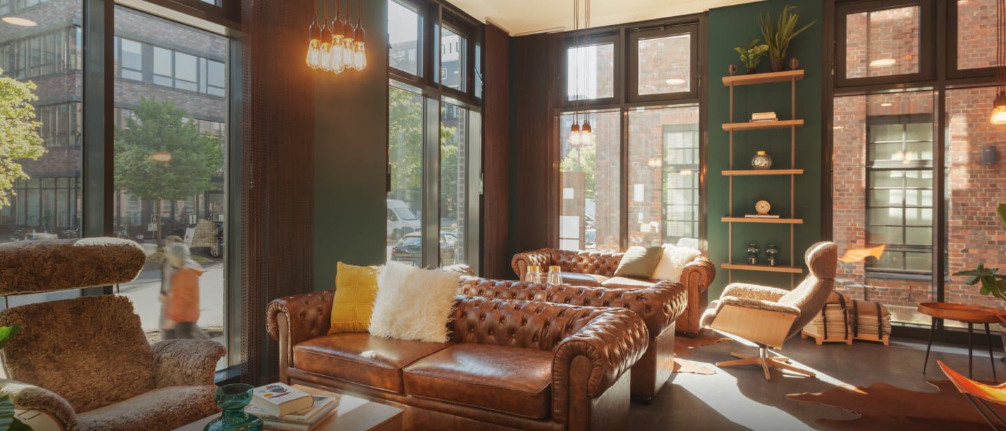 Cozy lounge with leather sofas, large windows, and decor.