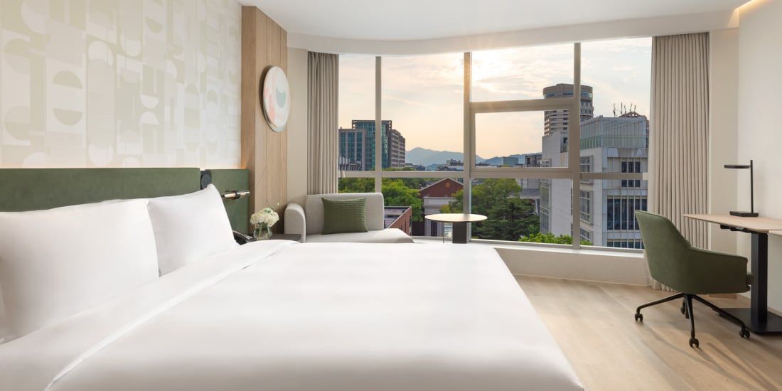 A view to the city from an earth-toned guest room at EVEN Hotel Hangzhou West Lake.
