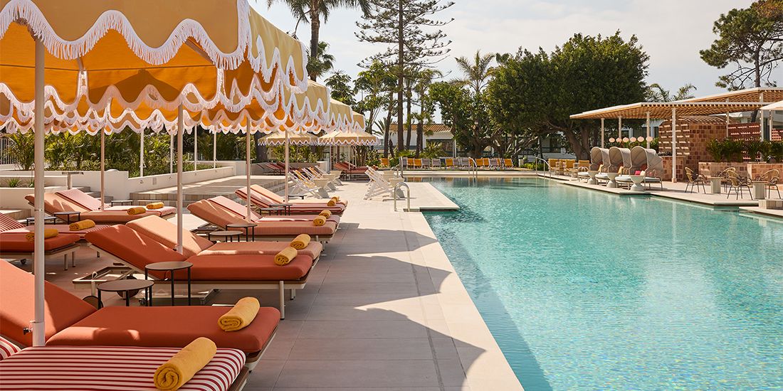 swimming pool surrounded by chaise lounges and umbrellas