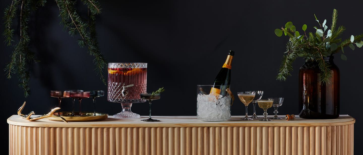 A selection of seasonal drinks atop a wooden bar, ready to welcome partygoers.