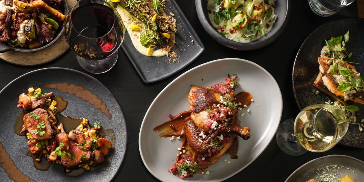 A table set with a variety of vibrant, savory dishes from poultry to asparagus.