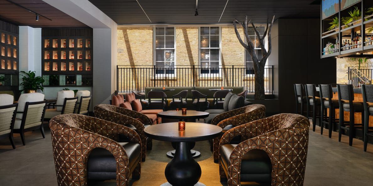 An open-air lounge and bar with cocktail tables for two.