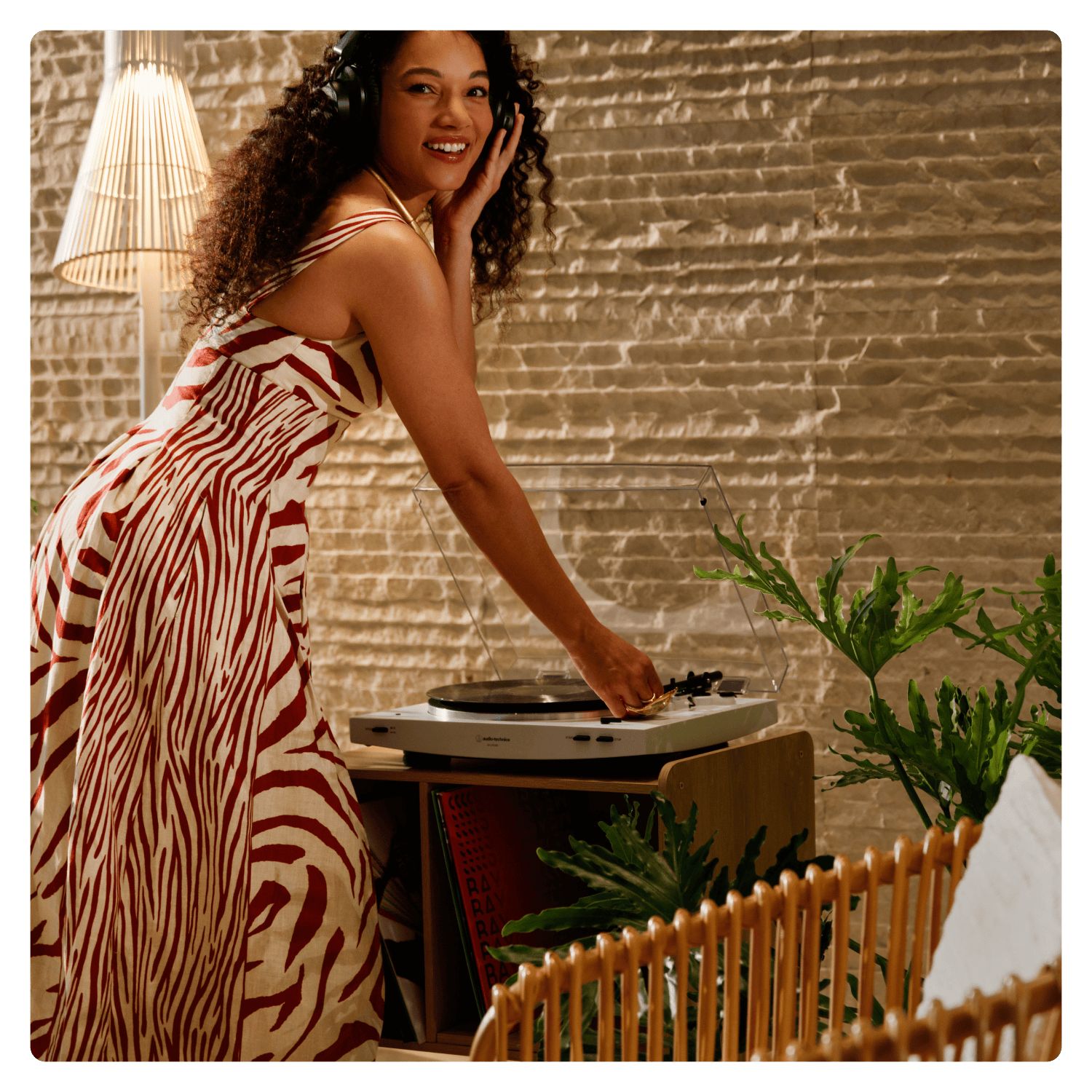 woman in a dress listening to a vinyl record