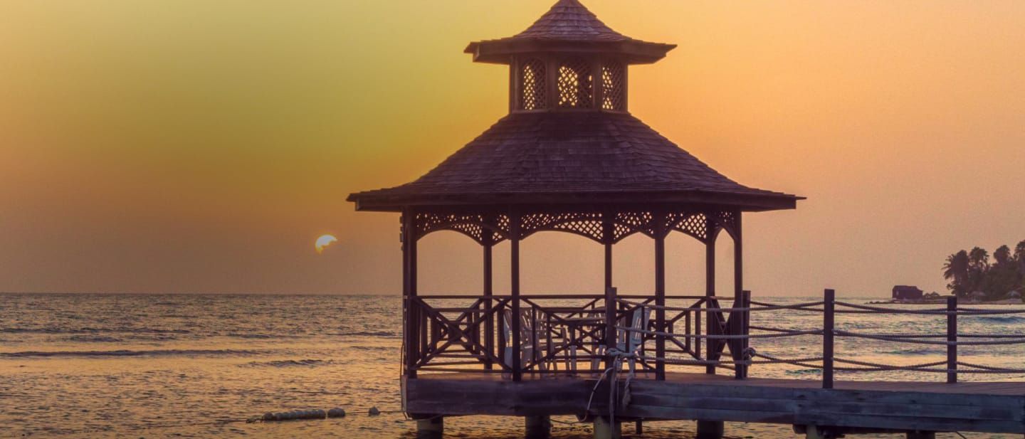 Gazebo at the end of a pier at sunset