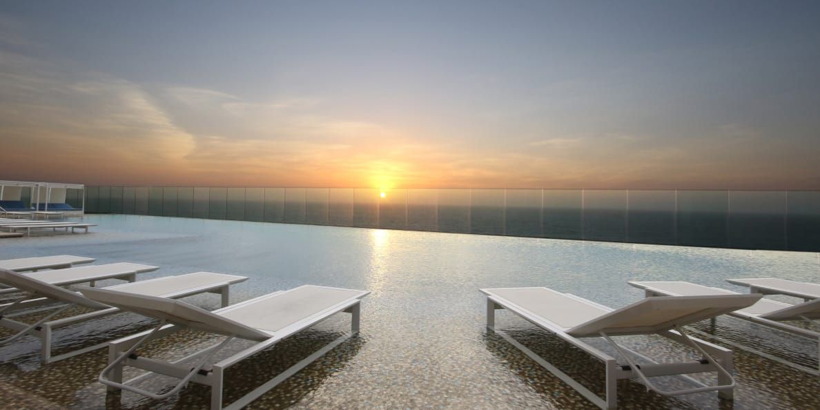 Infinity pool overlooking sunset on the ocean