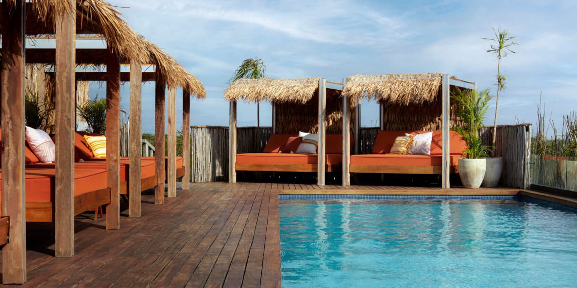 Poolside cabana beds with grass roofs