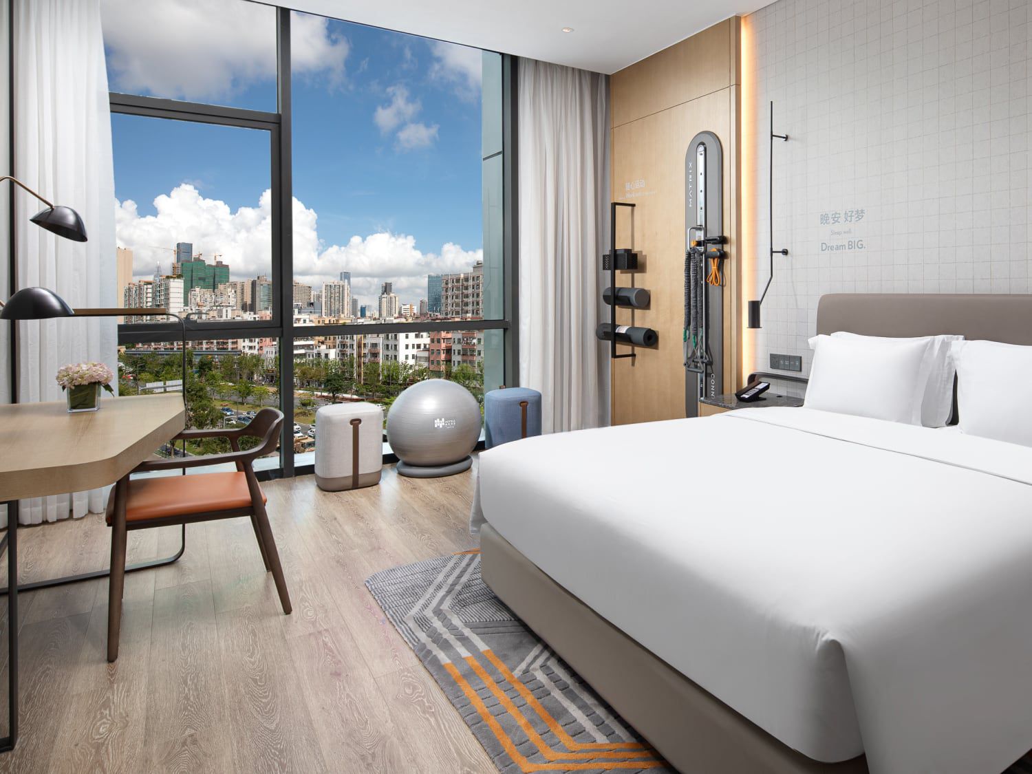 Guest bed, in-room fitness zone, and city views at EVEN Hotel Shenzhen Nanshan