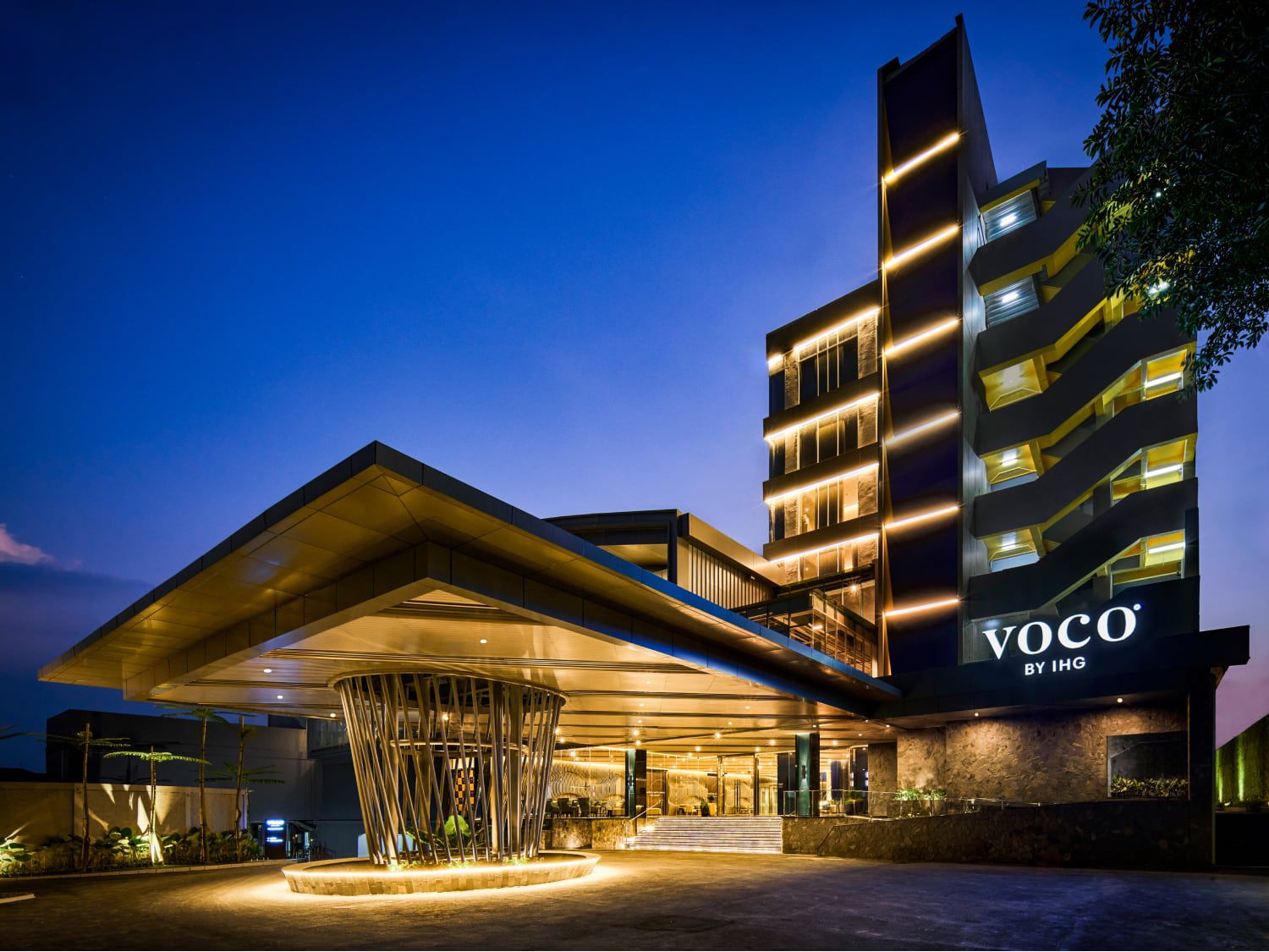 Soaring facade of voco Bandung Setiabudi glowing in the evening light