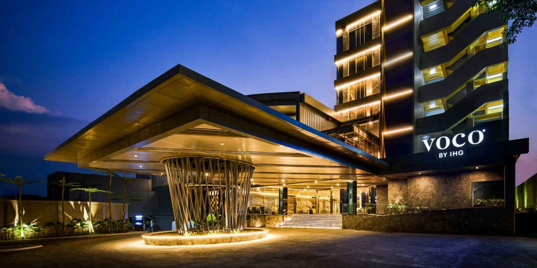 Soaring facade of voco Bandung Setiabudi glowing in the evening light