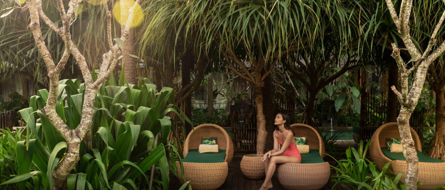 A woman sitting in a cabana looking up