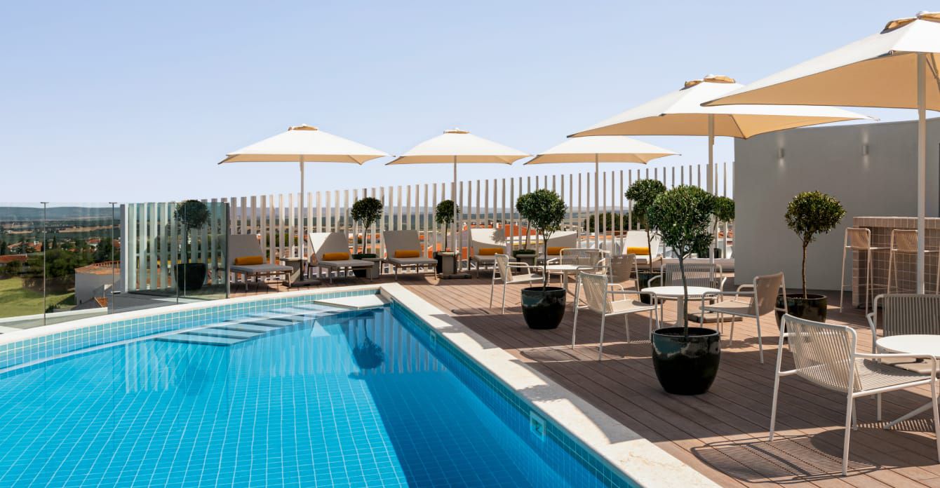 Rooftop pool with lounge seating and umbrellas