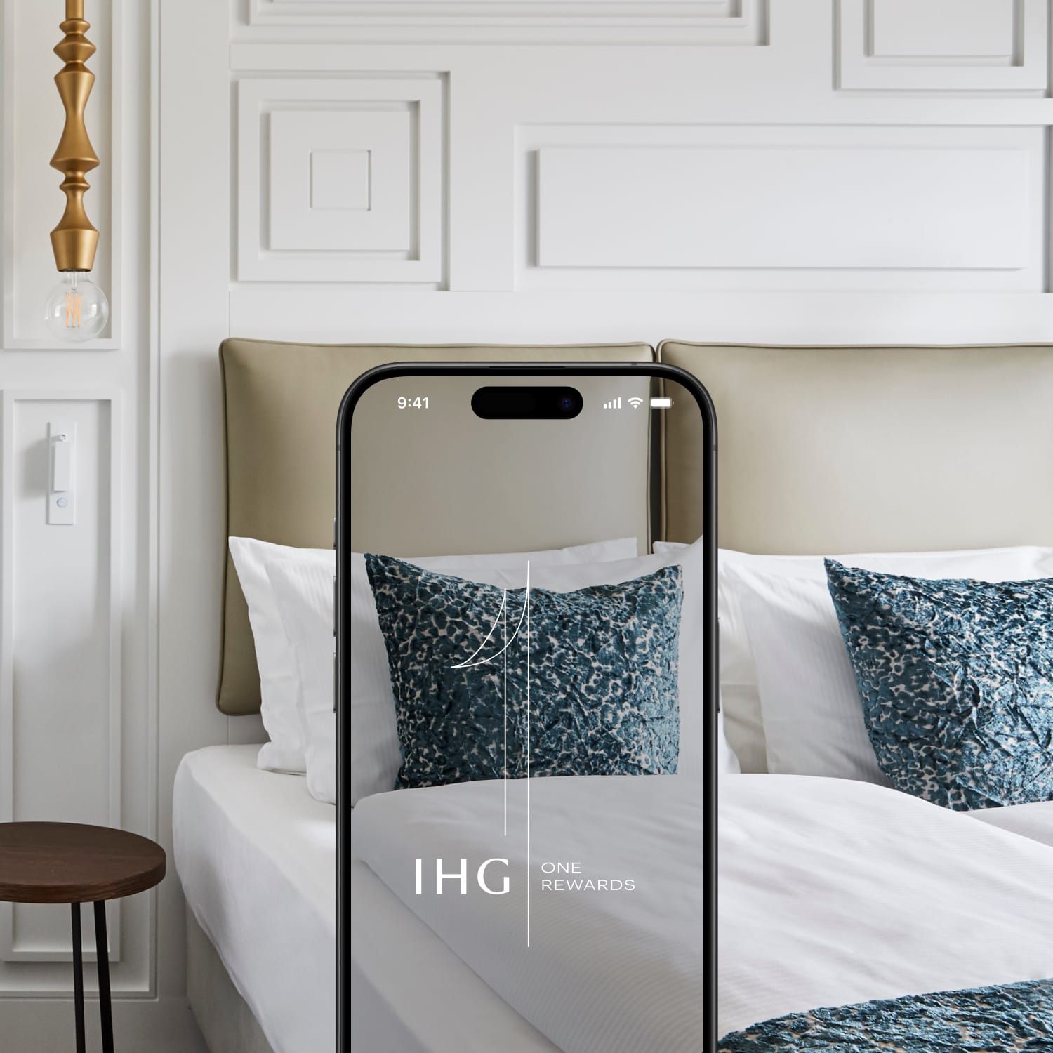 Hotel room with mobile device showing IHG One Rewards app
