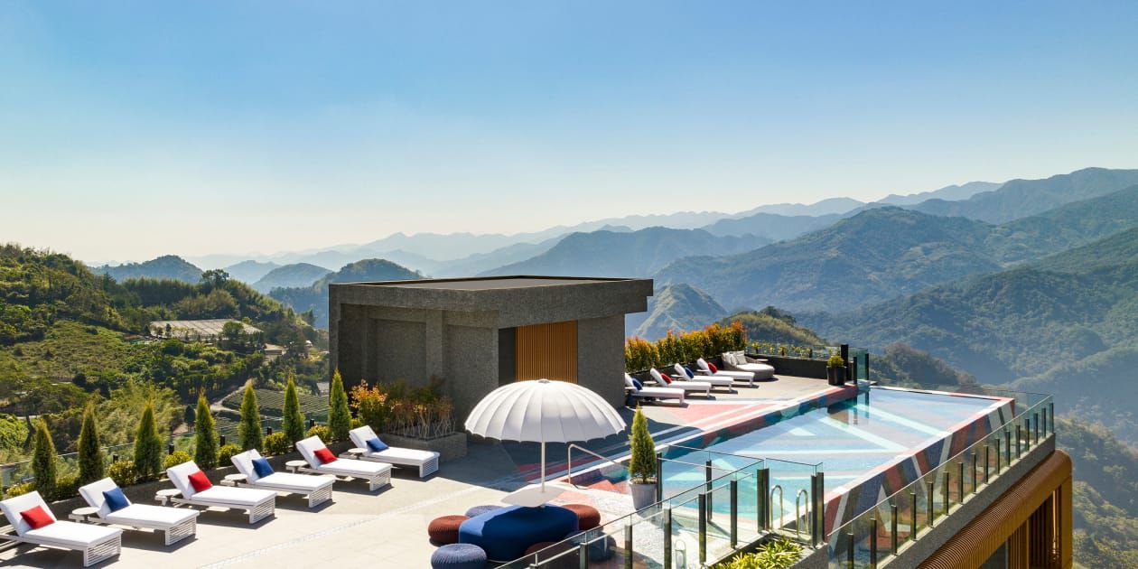 Image of hotel pool with a mountain view and greenery