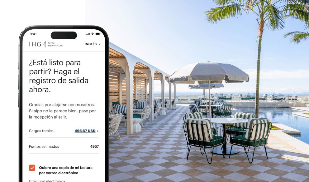 IHG app checkout interface on phone screen, poolside outdoor table seating