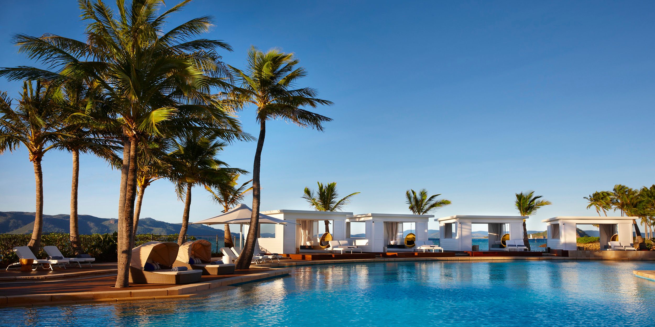 A stunning outdoor pool with cabanas under clear blue sky