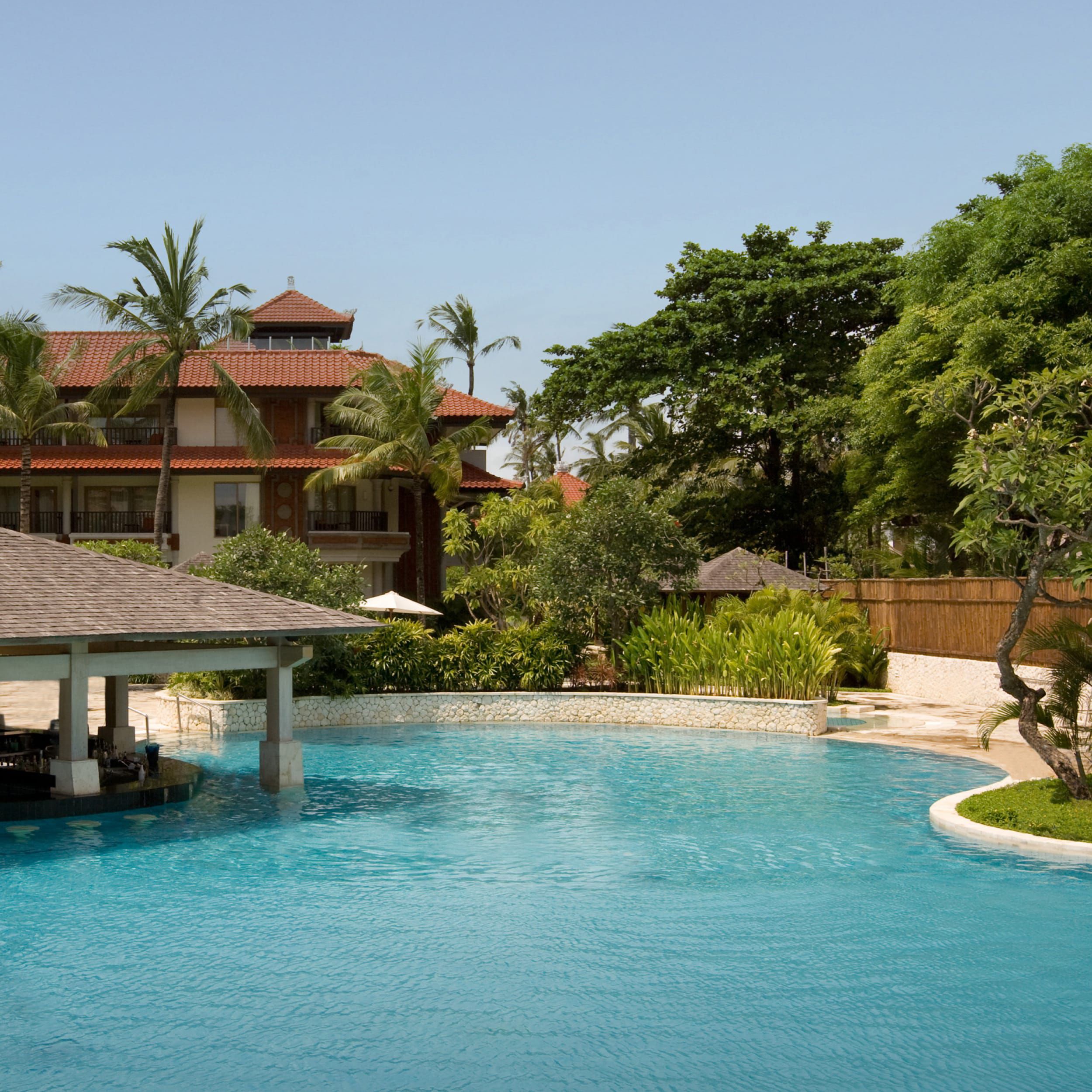 Hotel pool with pool pavillion and lush greenery