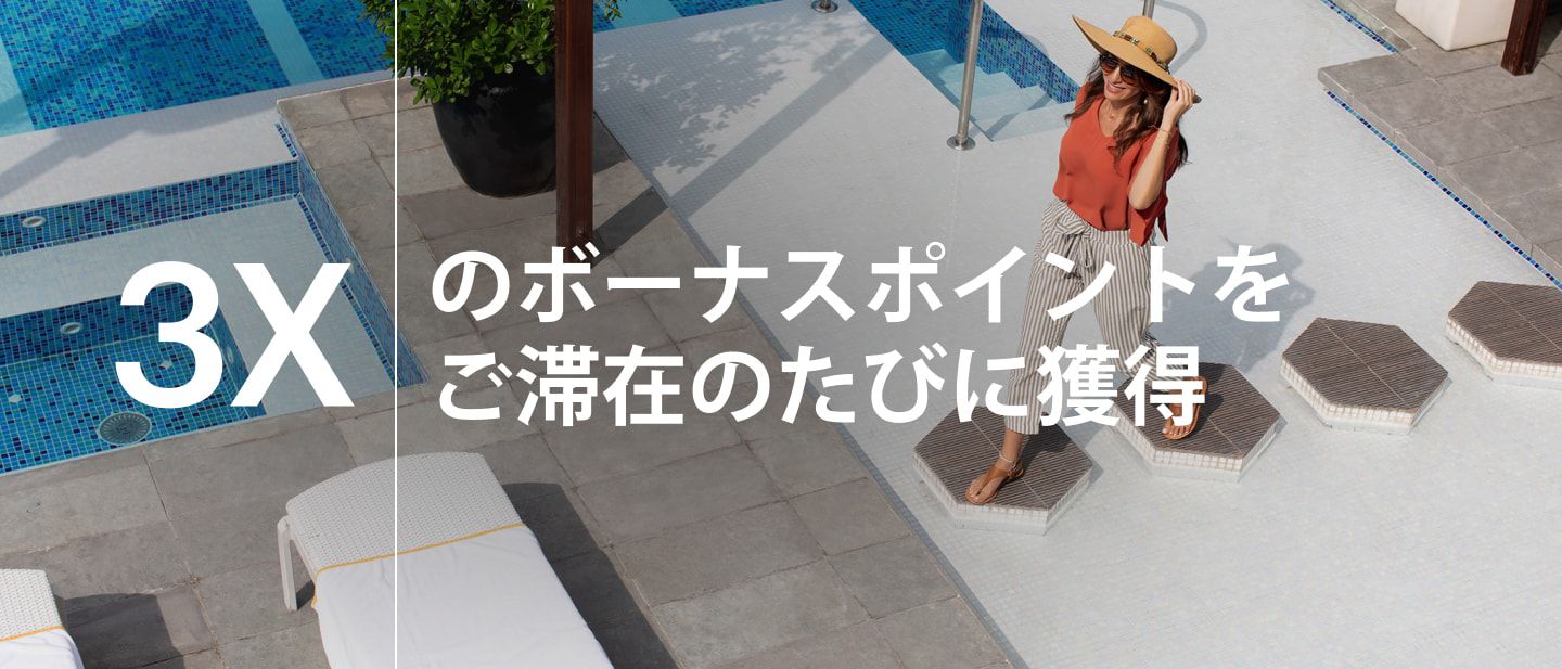 vocoドバイのプールデッキを歩く女性