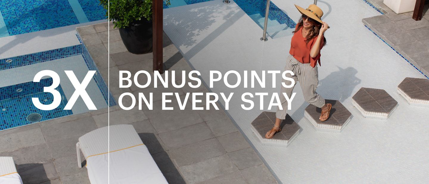 Woman walking across pool deck at voco Dubai