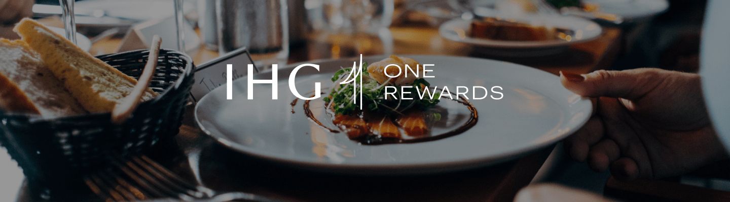IHG One Rewards logo over a photo of a decadent dinner meal