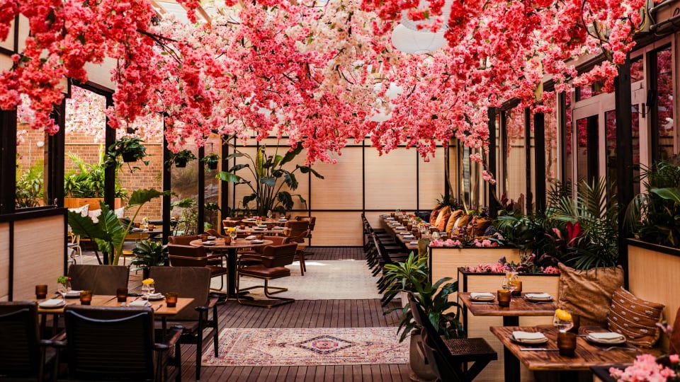 A dining room with a ceiling full of pink blooming flowers