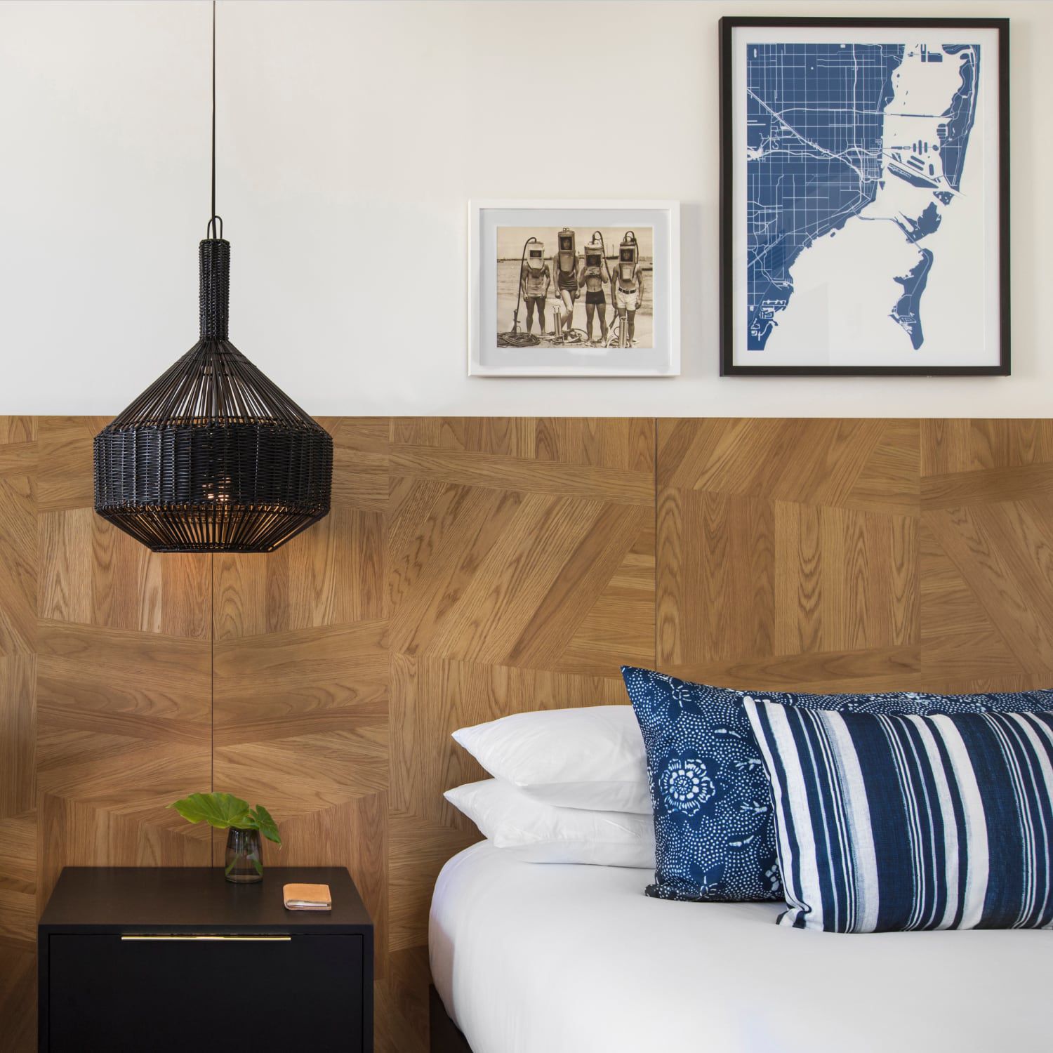 A restaurant space with floor-to-ceiling windows, gauzy curtains, and long tables set for eight.