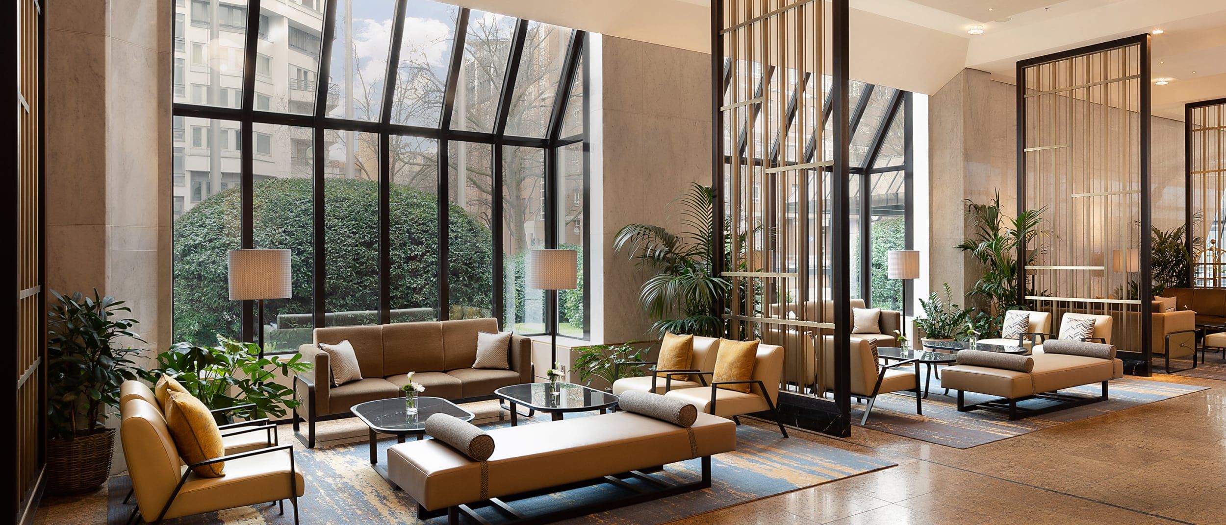 An earth-toned lobby with floor-to-ceiling windows.