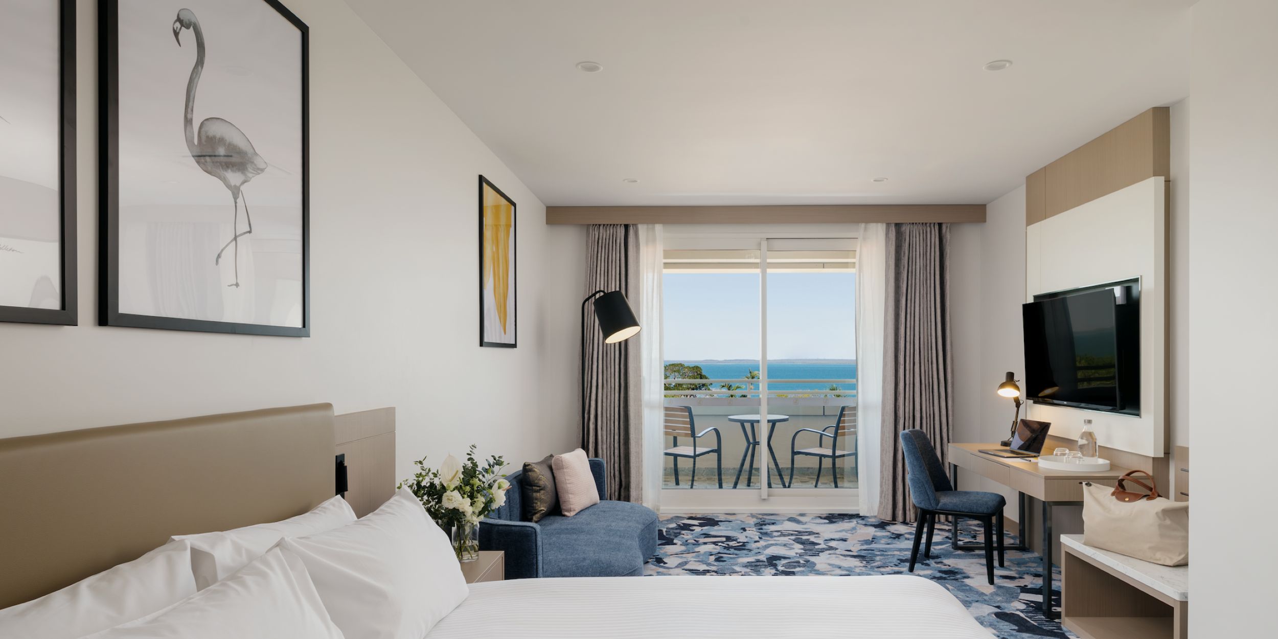 A warm and inviting hotel room with a balcony and ocean views