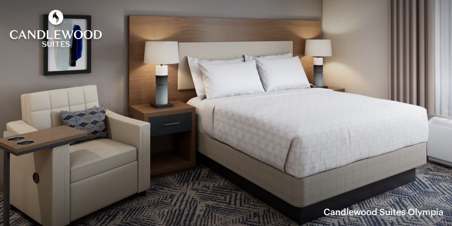  DFW West Candlewood Suites'in uygun ve mükemmel donanımlı queen yataklı konuk odası.