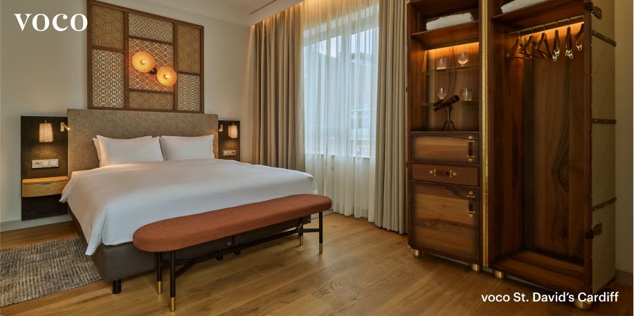  Ein makelloses, ruhiges King-Zimmer im voco The Hague mit einem eleganten, hintergrundbeleuchteten Kleiderschrank.
