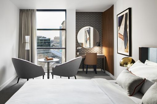 Large bedroom with seating area and city view