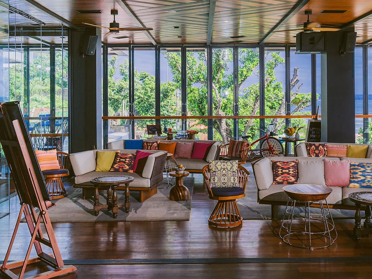 Bohemian common area filled with couches and an art easel