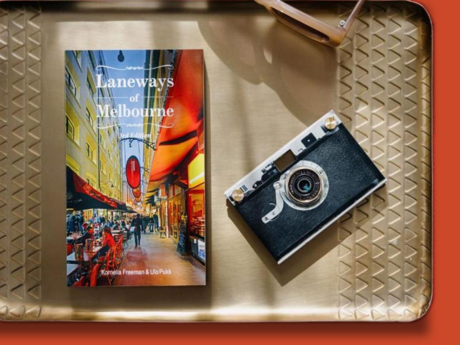 "Laneways of Melbourne" book and vintage camera displayed on a tray