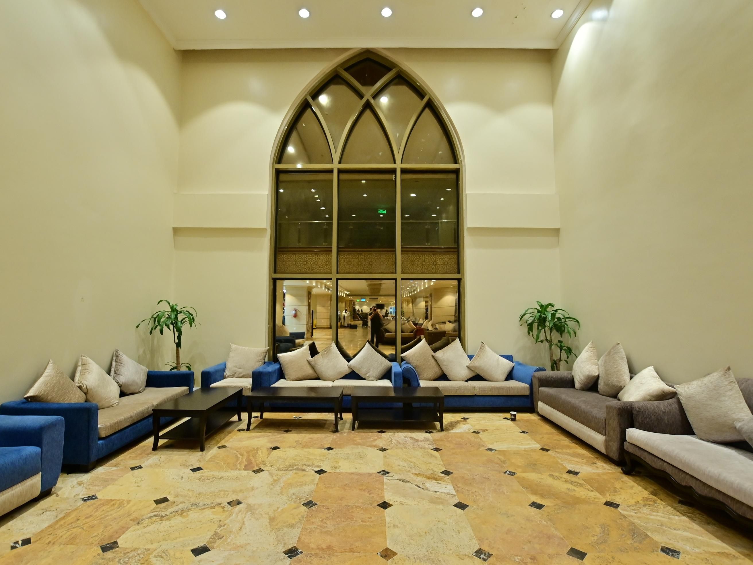 The lobby of the hotel has many sitting and waiting areas and has a coffee shop .