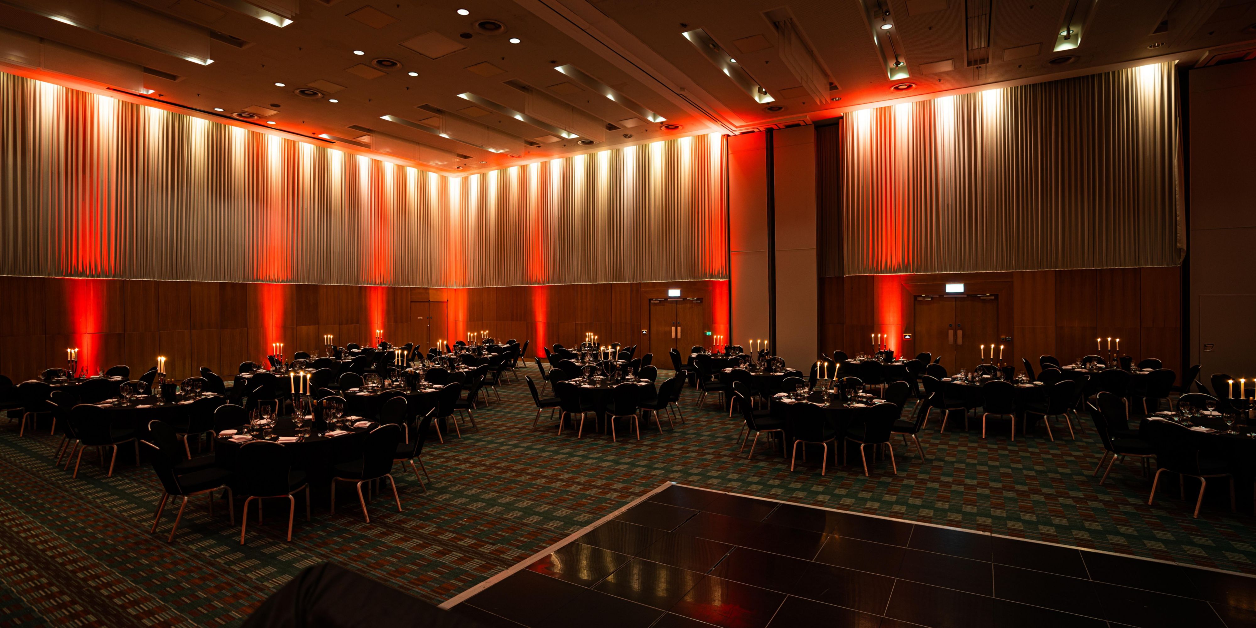 Manchester Deansgate large event venue hire with red low lighting and many tables and chairs