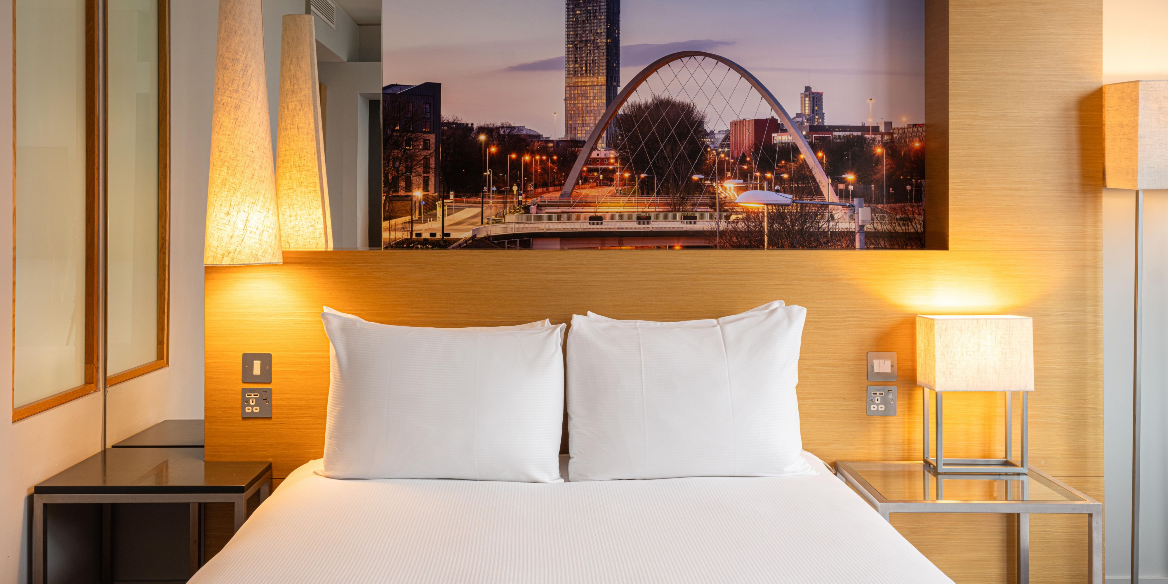 hotel guest room with a printed image of Manchester on the back wall