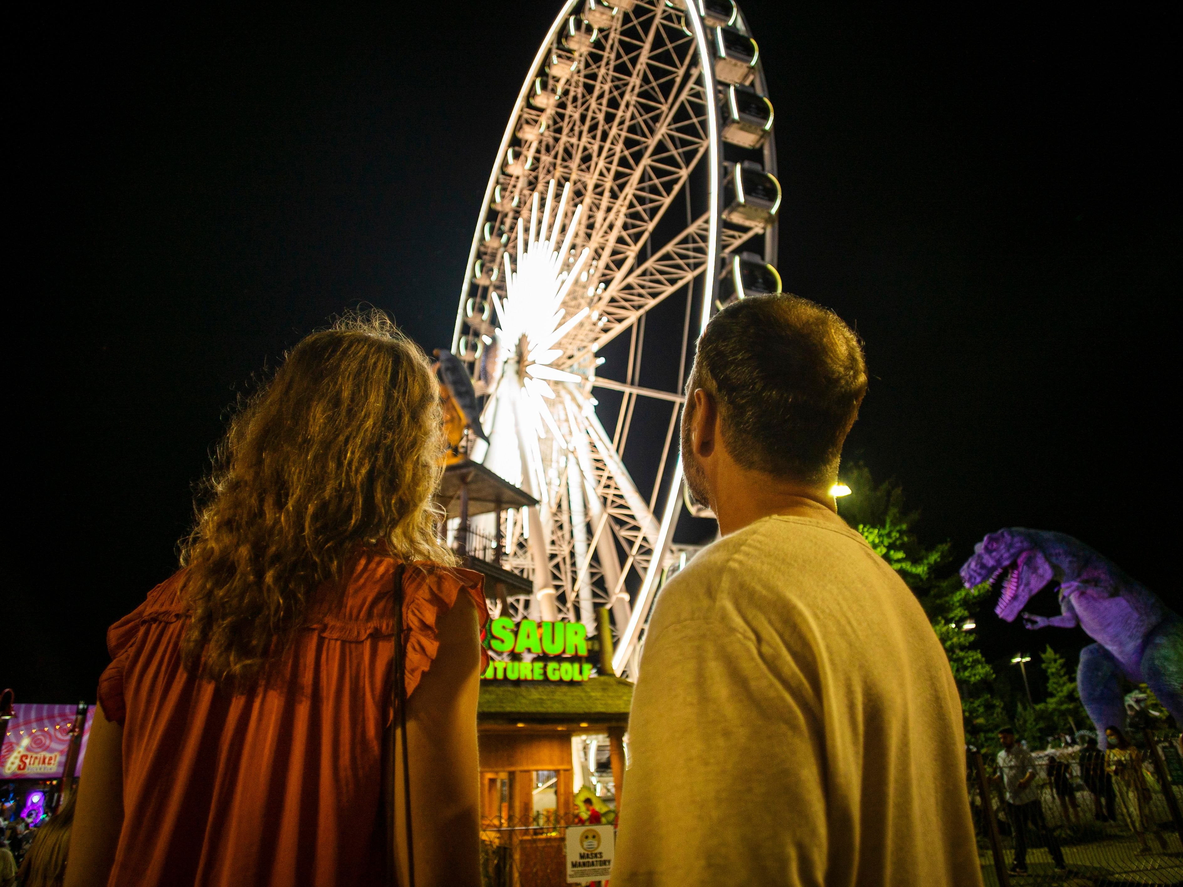couple looking up at Niagara skywheel at night