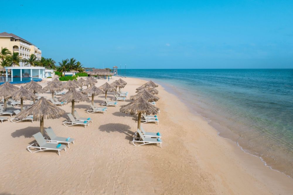 View of lounge chairs and thatch umbrellas on the beach in Montego Bay