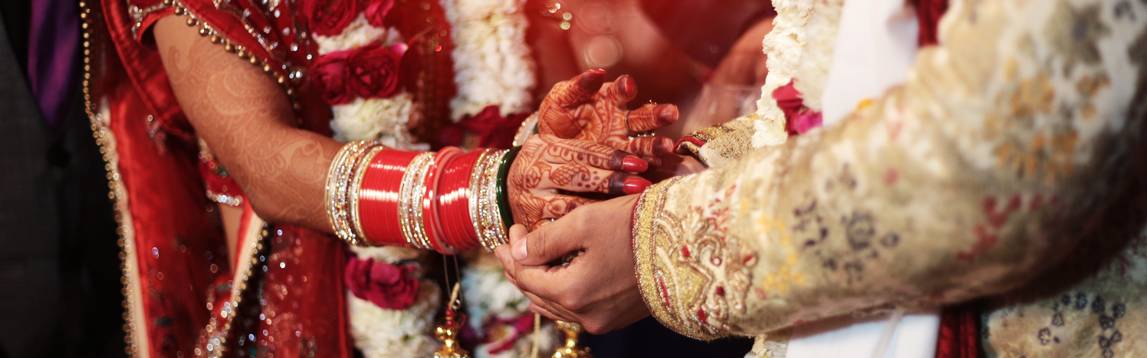 Couple at an Indian wedding holding hands in ceremony.