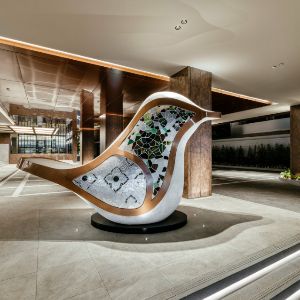 Modern hotel lobby featuring artistic bird sculpture centerpiece