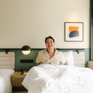Person relaxing in a hotel bed.