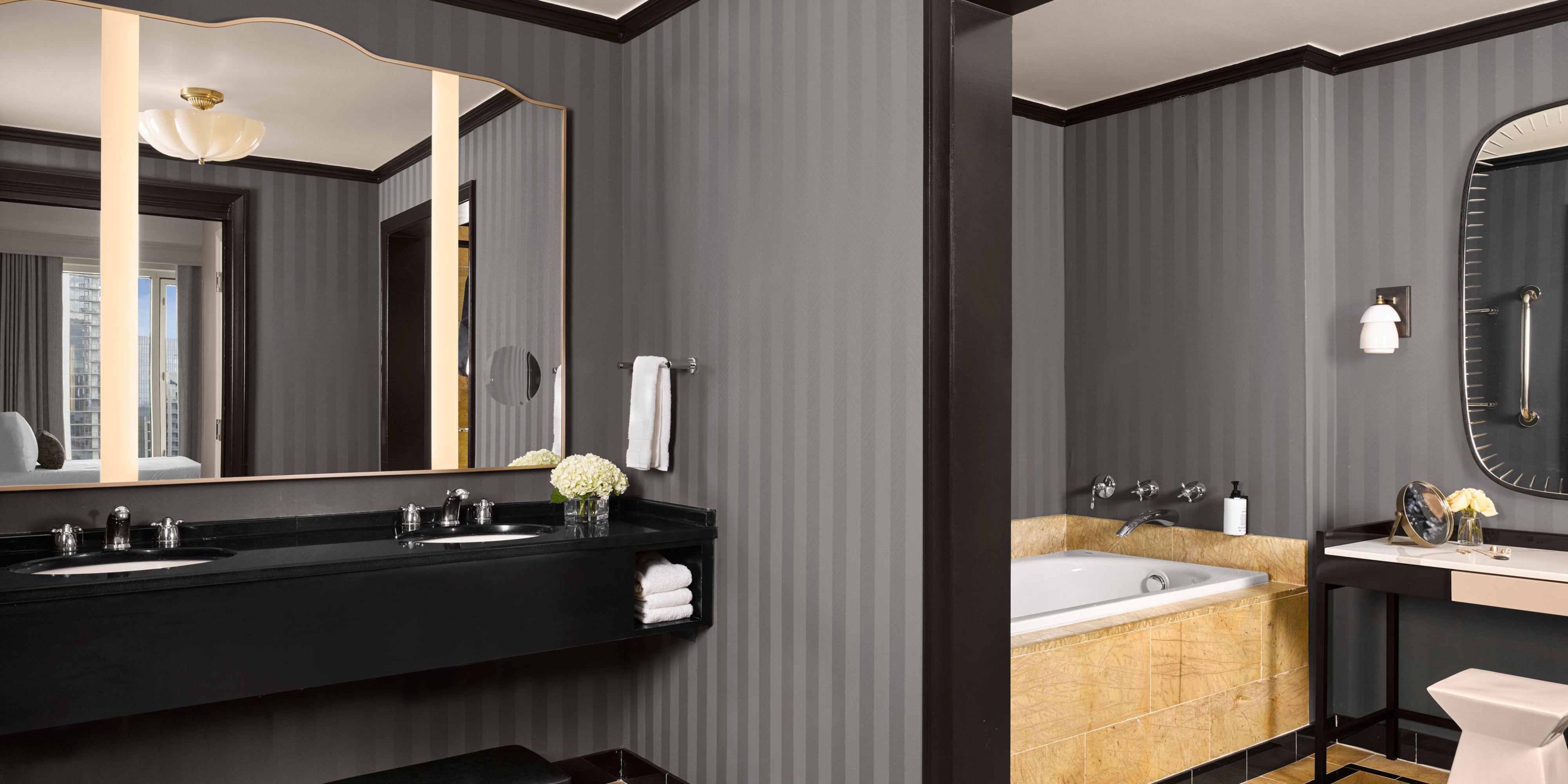 Ambassador Suite bath with double sinks, tub and dressing table.