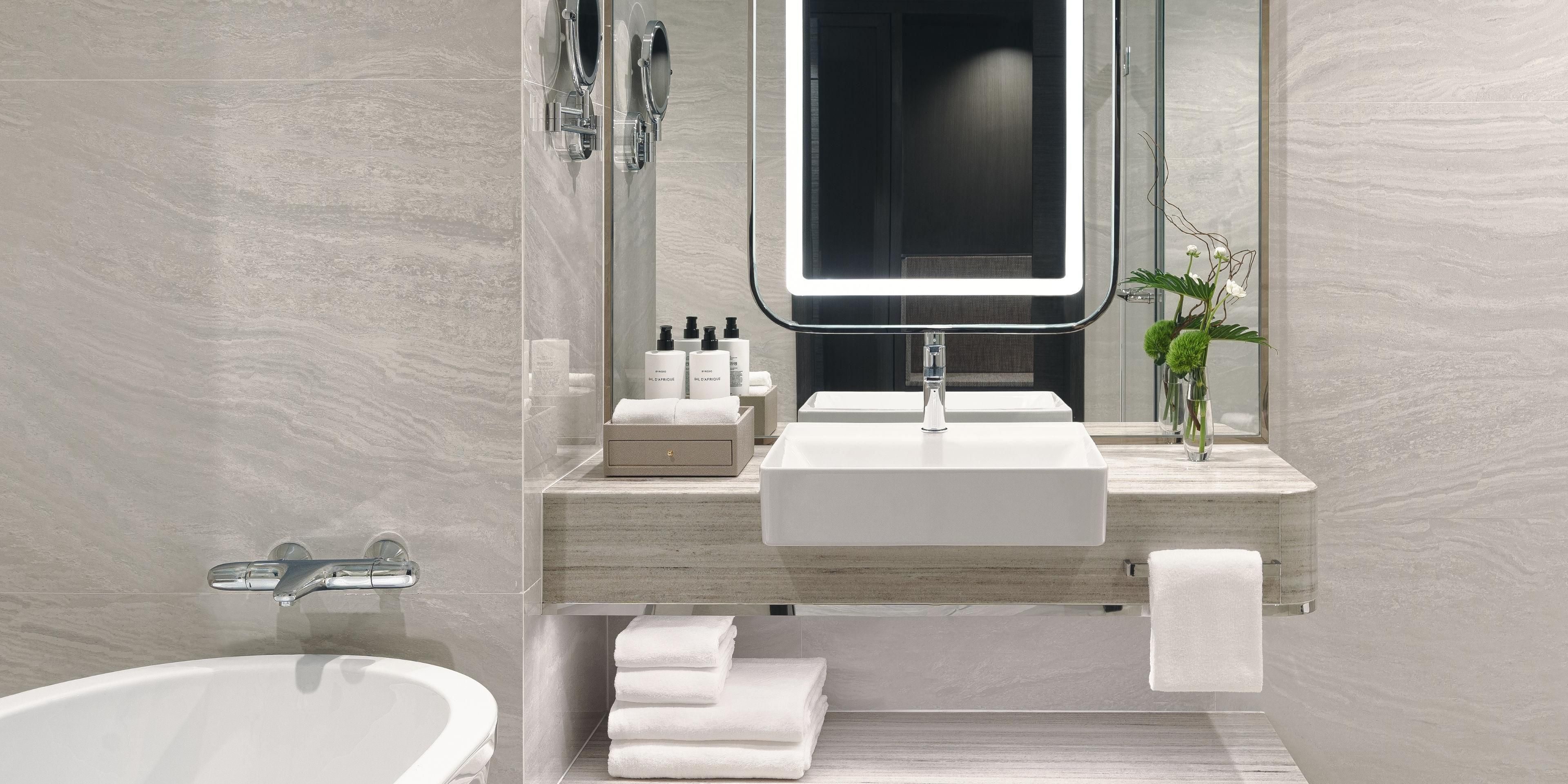 Indulge in luxury with complimentary Byredo wash amenities in your ensuite, featuring a spacious rain shower and a separate tub for ultimate relaxation.