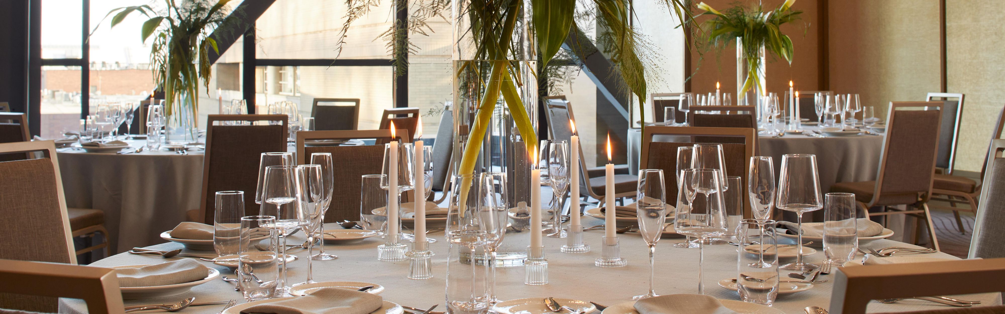 Event space with round tables set with decorations.