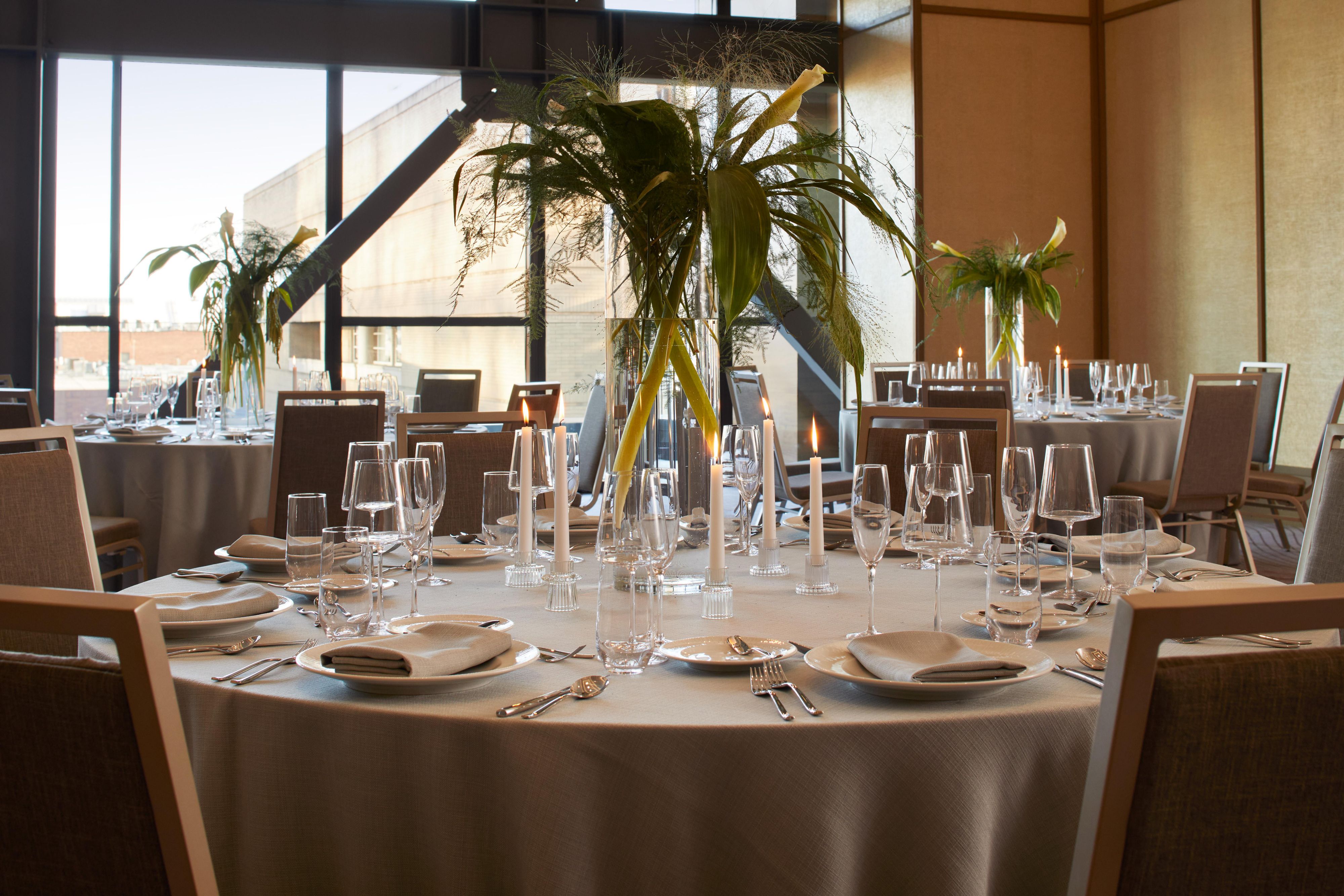 Event space with round tables set with decorations.