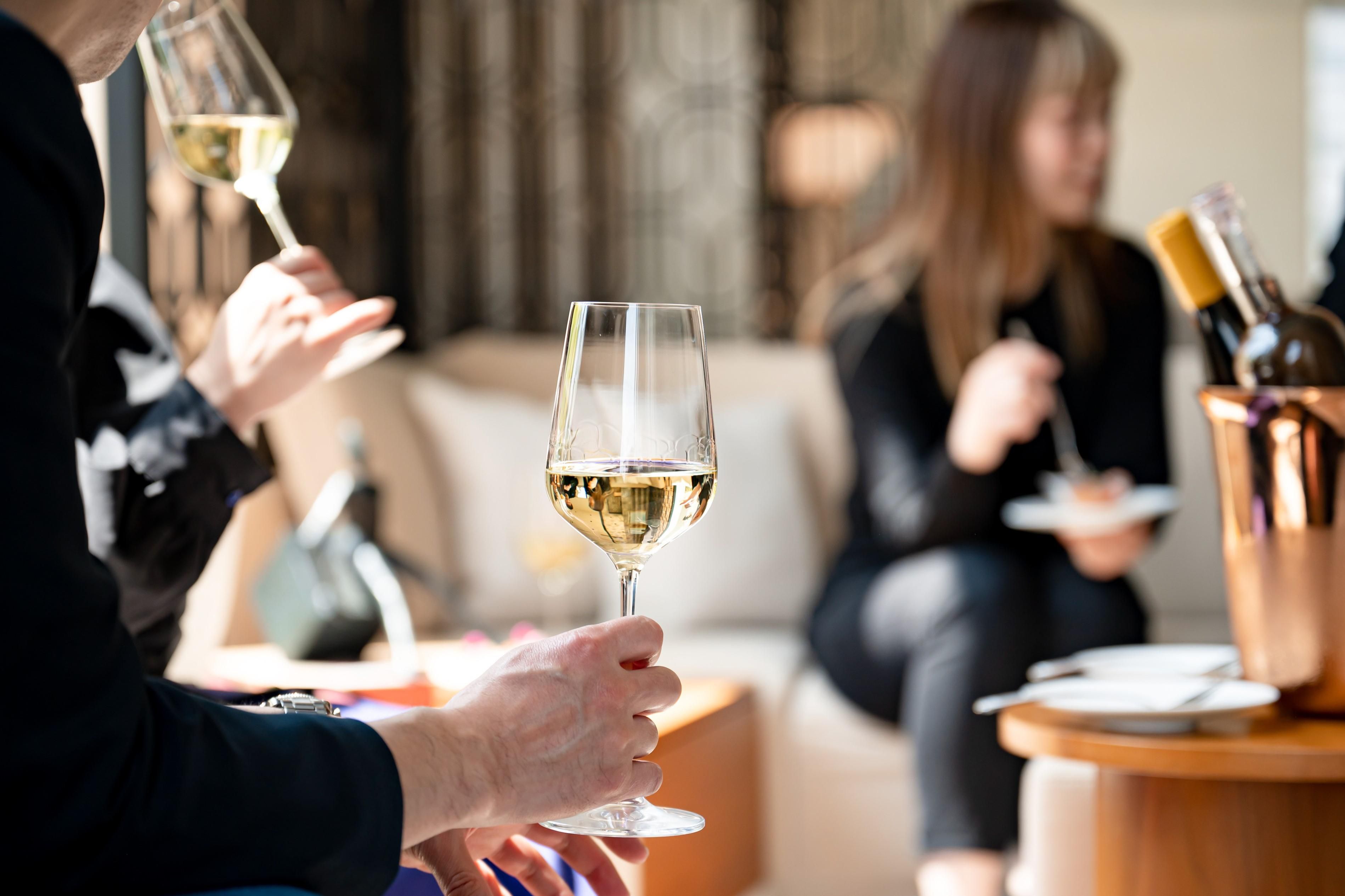 Guests sitting and enjoying glasses of wine.