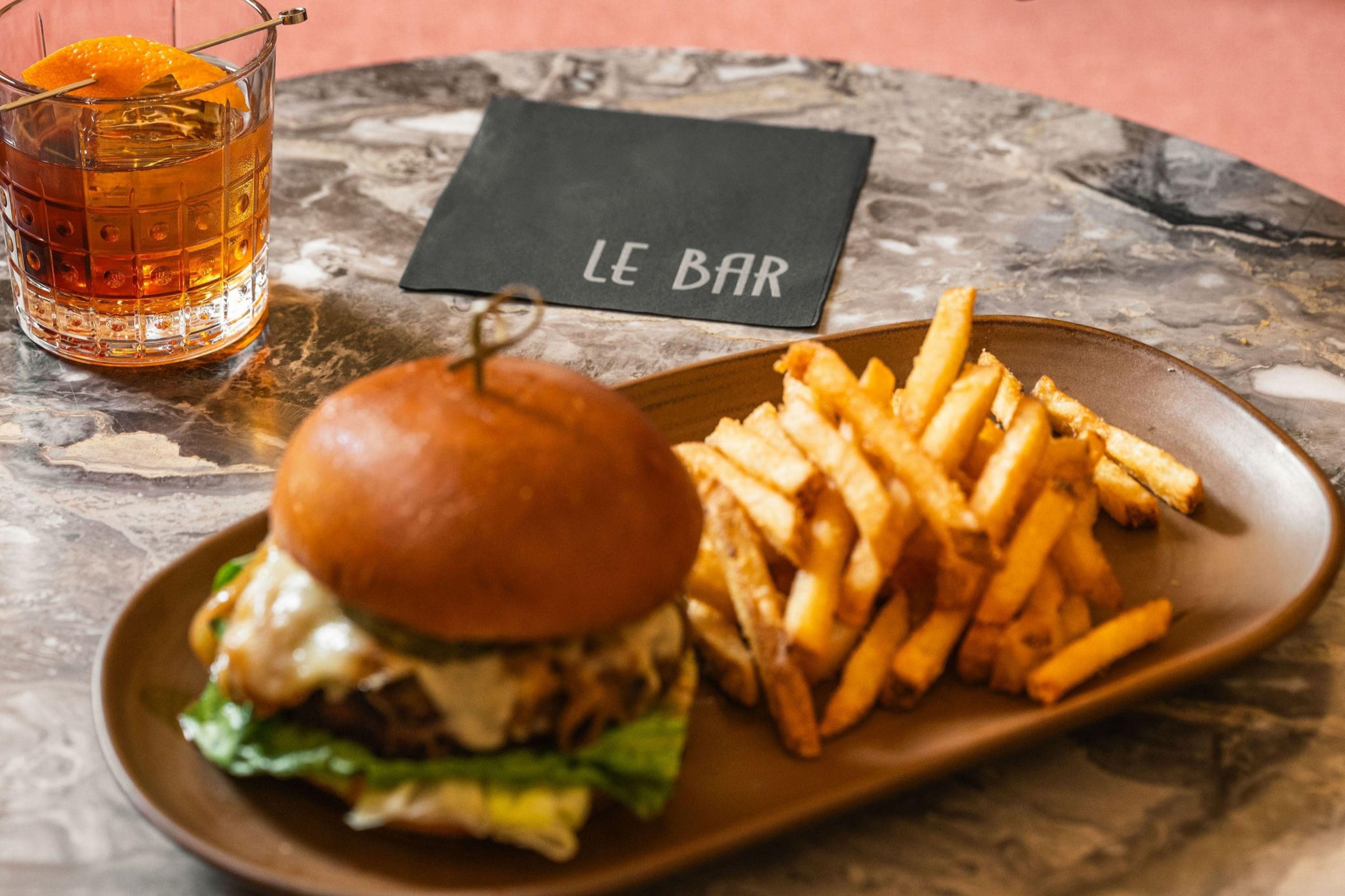 Burger, fries, and a whiskey cocktail from Le Bar.