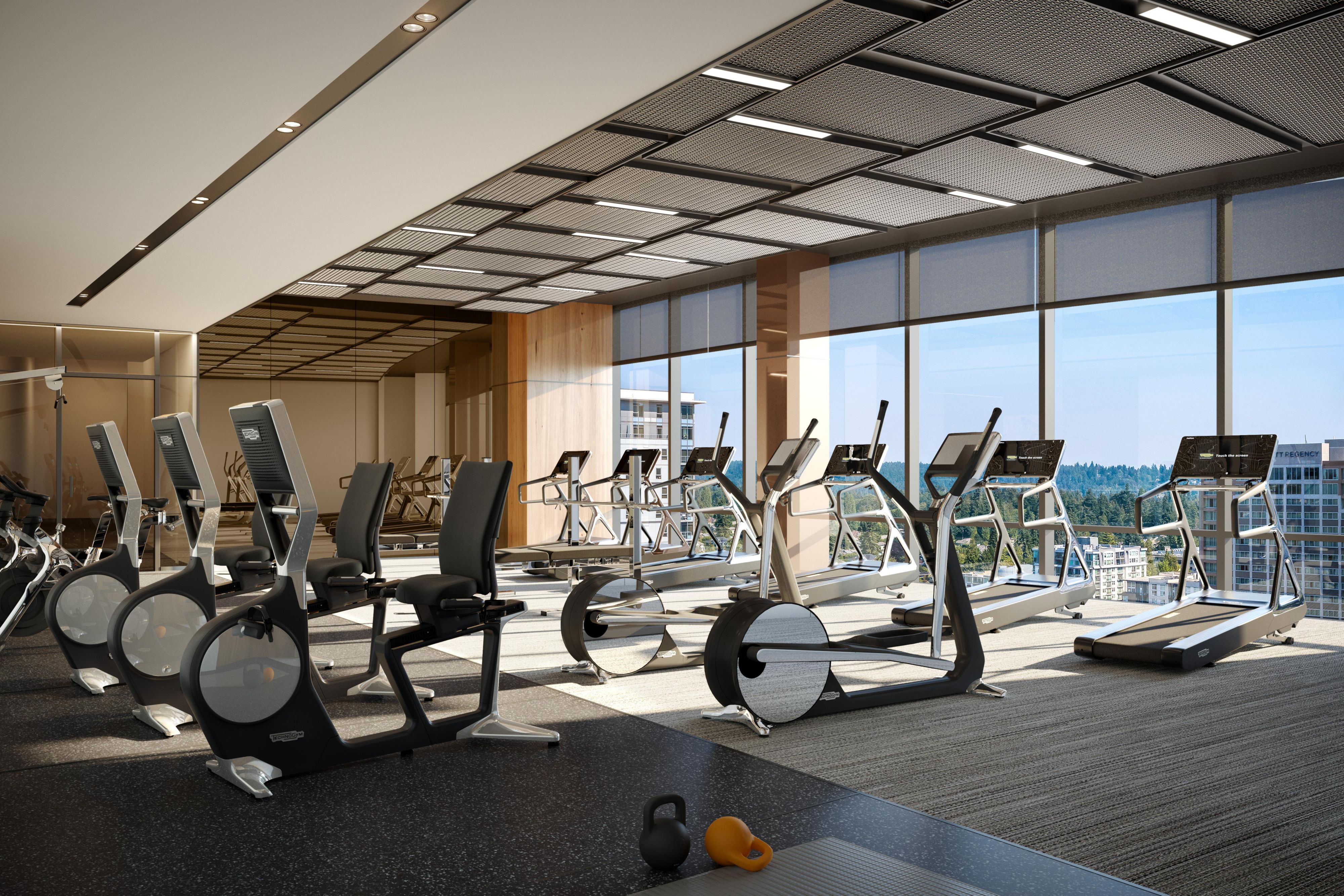 Fitness center with various cardio equipment, like treadmills and elliptical machines, overlooking a city view.