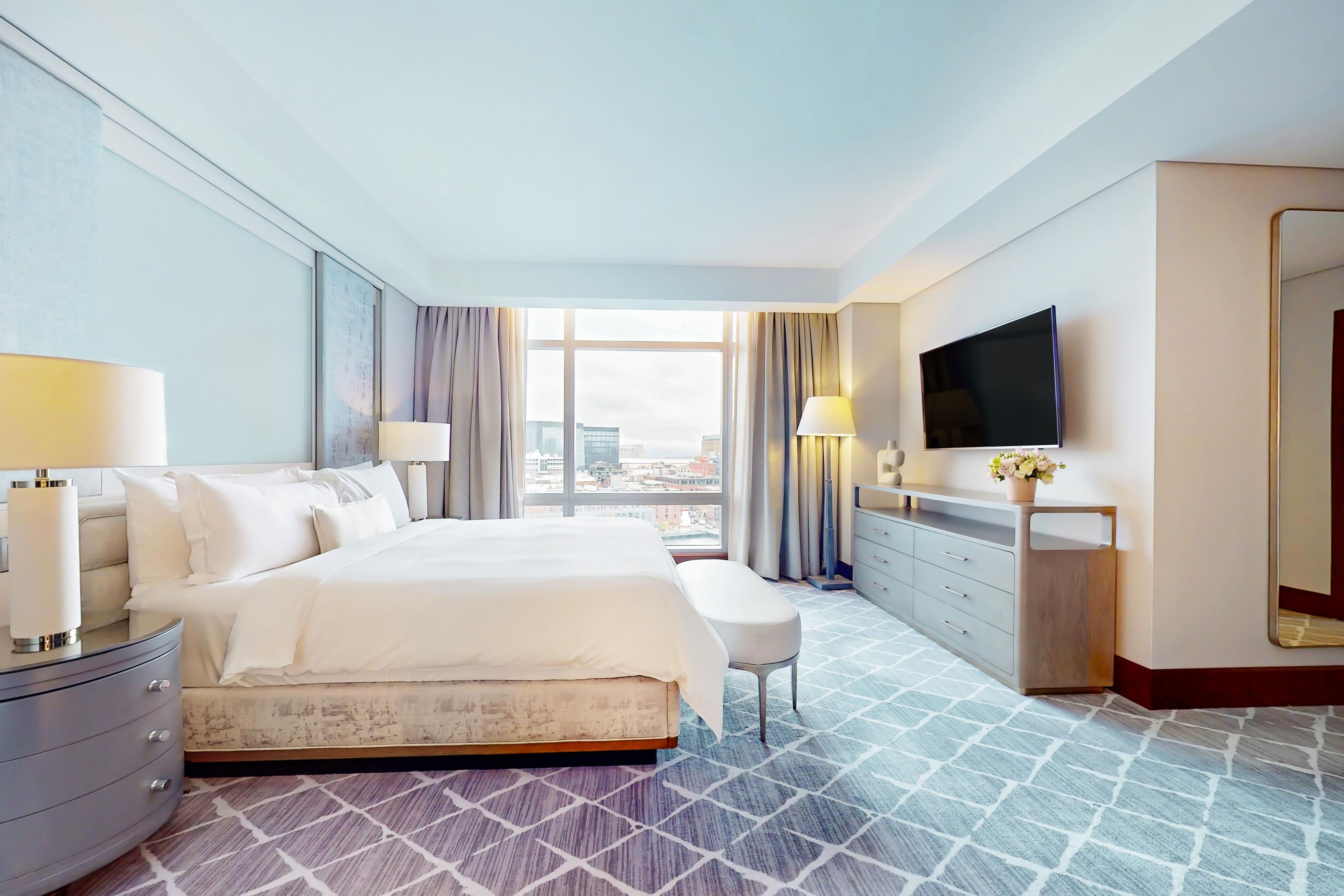 Hotel suite with upscale furniture and city views.